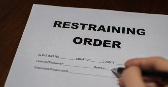 Individual filling out a restraining order.