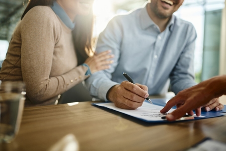 happy couple signing a document in an office