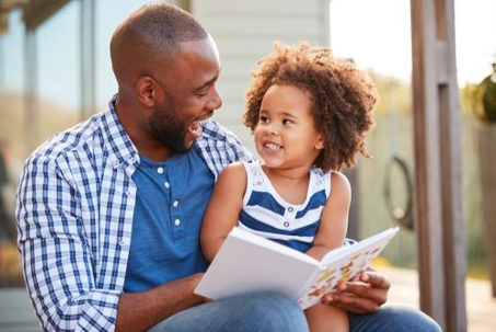 father and son reading a storybook