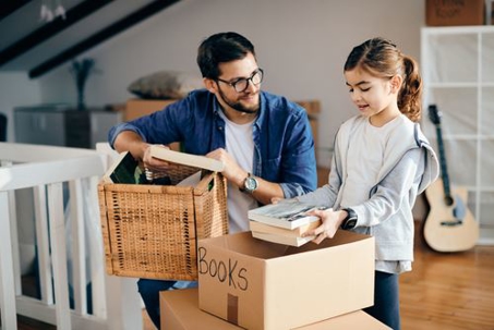 father and daughter unpacking moving boxes