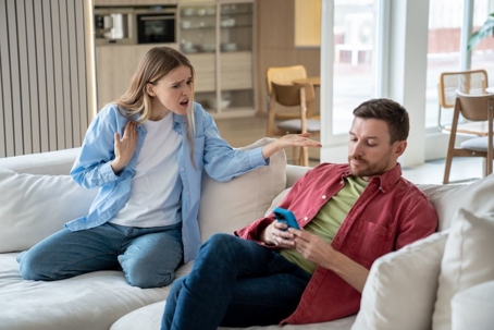 indifferent ignoring man sits on sofa