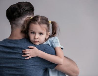 little girl being held by her father