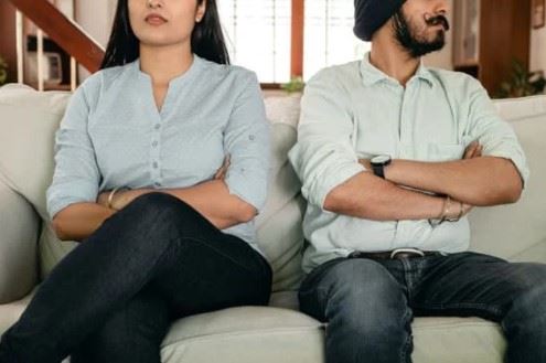 man and woman facing away from each other arms crossed