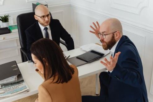 man being aggressive towards wife in front of lawyer