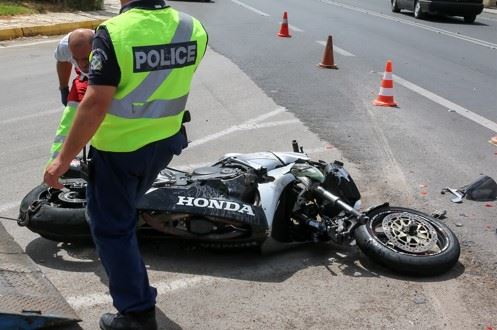 wrecked motorcycle on the side of the road with police officer